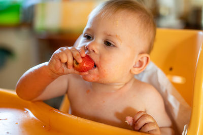 Cute baby girl eating fruit