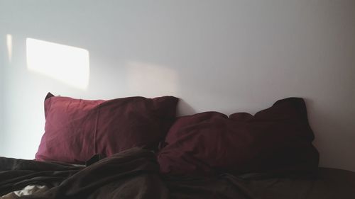 Red and white house on bed against wall at home