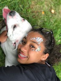 Portrait of smiling girl with eye make-up holding dog