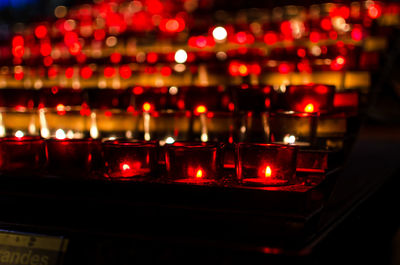 Lit candles on rack in church