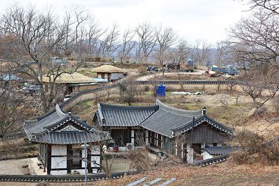 High angle view of houses and trees on field against sky