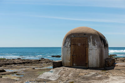 Old built structure by sea against sky