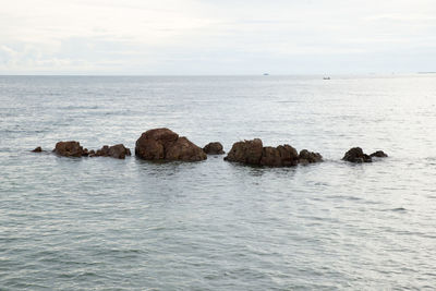 Rocks in sea against sky