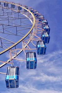 Low angle view of ferris wheel against blue sky