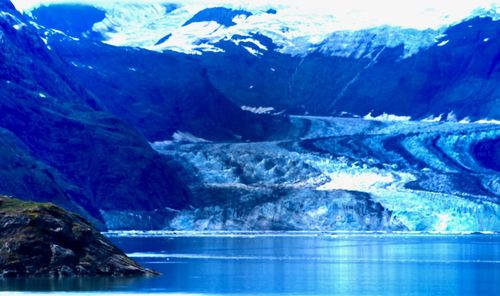 Scenic view of lake and mountains against blue sky