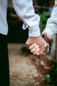 Midsection of couple holding hands