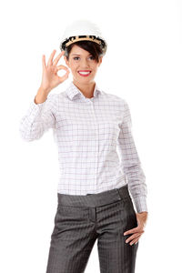 Portrait of smiling young woman standing against white background