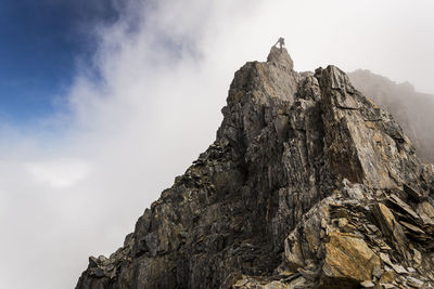 Figure rappelling from the top of a mountain buttress in new zealand