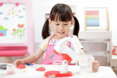 Portrait of cute girl sitting at table