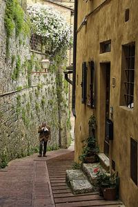 Full length of man standing amidst buildings in alley