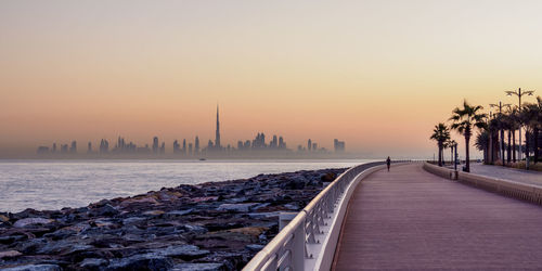 Panoramic view of sea and buildings against sky during sunset