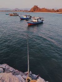 Sailboats moored on sea against sky