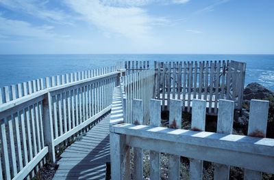 View of pier on sea against blue sky