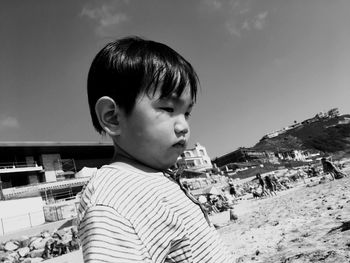 Portrait of boy looking away against sky