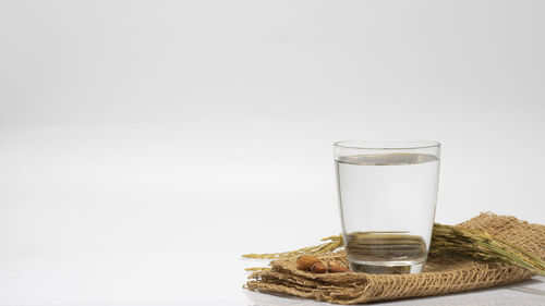 Glass of water on table against white background