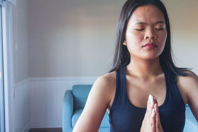 Focused young woman meditating while practicing yoga