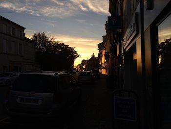 Vehicles on road at sunset