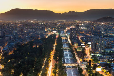 High angle view of illuminated city against sky during sunset