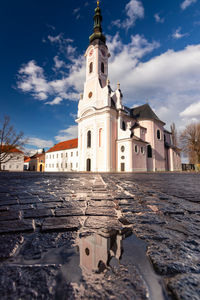 Square saint teresa of avila and church in pozega. low view with reflection.