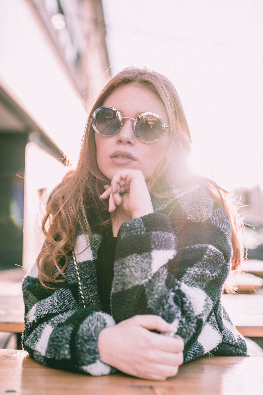 one person, real people, front view, portrait, women, lifestyles, glasses, leisure activity, holding, females, sitting, young adult, indoors, winter, young women, looking at camera, casual clothing, clothing, warm clothing, hairstyle