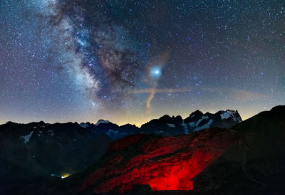 Scenic view of mountains against sky at night