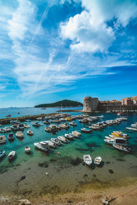 Sailboats moored in sea against sky
