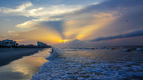 Scenic view of beach against sky during sunset