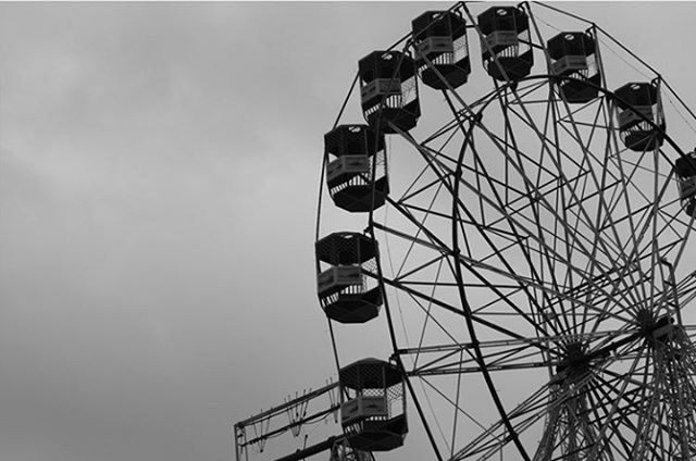 low angle view, sky, built structure, architecture, arts culture and entertainment, building exterior, amusement park, ferris wheel, amusement park ride, day, outdoors, lighting equipment, cloud - sky, metal, modern, no people, tall - high, clear sky, street light, technology