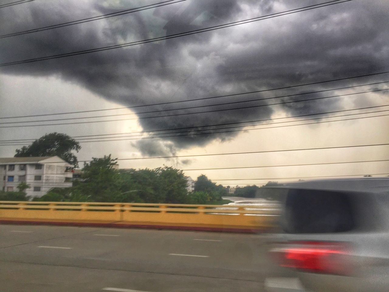 BLURRED MOTION OF ROAD AGAINST CLOUDY SKY