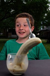 Portrait of boy holding ice cream on table