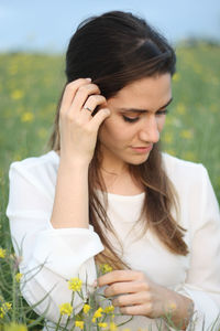 Close-up of beautiful young woman standing against plants