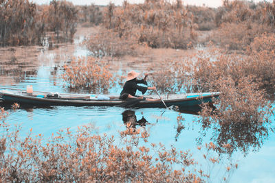 Side view of man on boat in lake