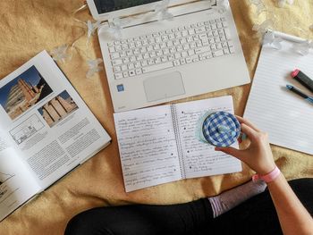 High angle view of woman reading book on table