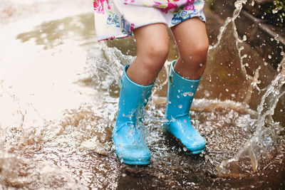 Low section of girl splashing on water