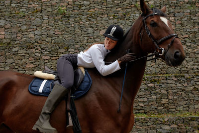 Horse standing against brick wall