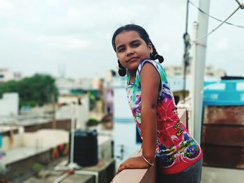 Portrait of girl standing on terrace in city