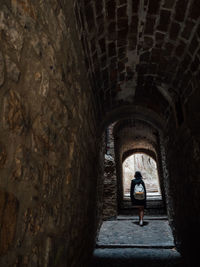 Woman walking in dark tunnel