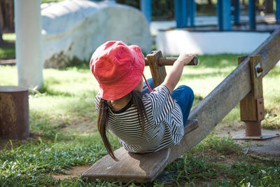 Cute girl playing on seesaw at park
