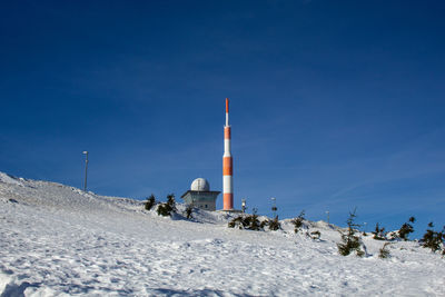 Snow covered land against blue sky