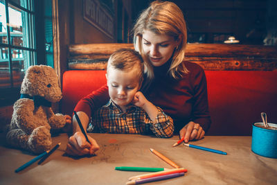 Cute girl and son on table