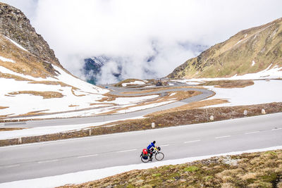 Scenic view of person riding bike on snow covered landscape