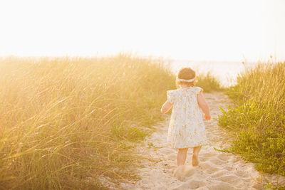 Rear view of girl standing on field