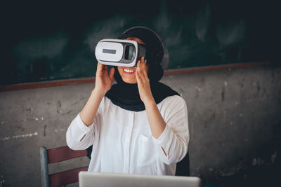 Female teacher using virtual reality simulator in classroom