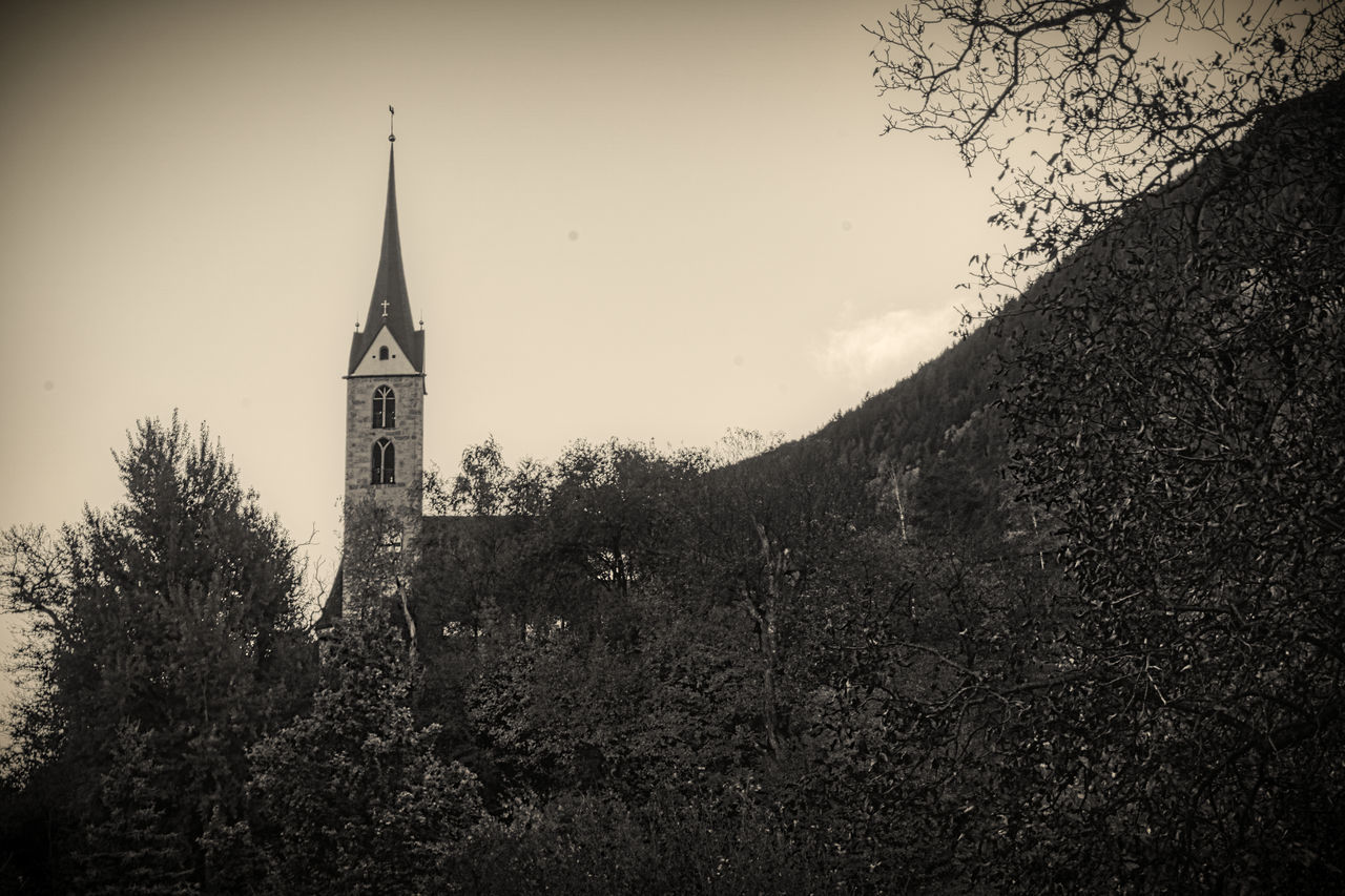 TOWER AMIDST TREES AGAINST SKY