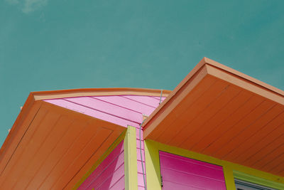 Low angle view of multi colored building against blue sky