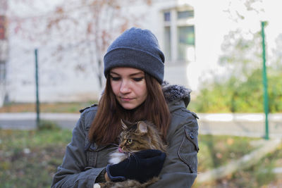 Close-up of young woman holding kitten