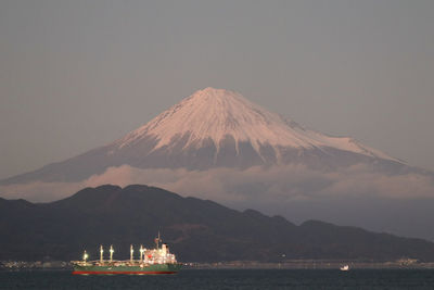 Scenic view of sea and mountains against clear sky