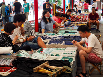 People sitting at market stall