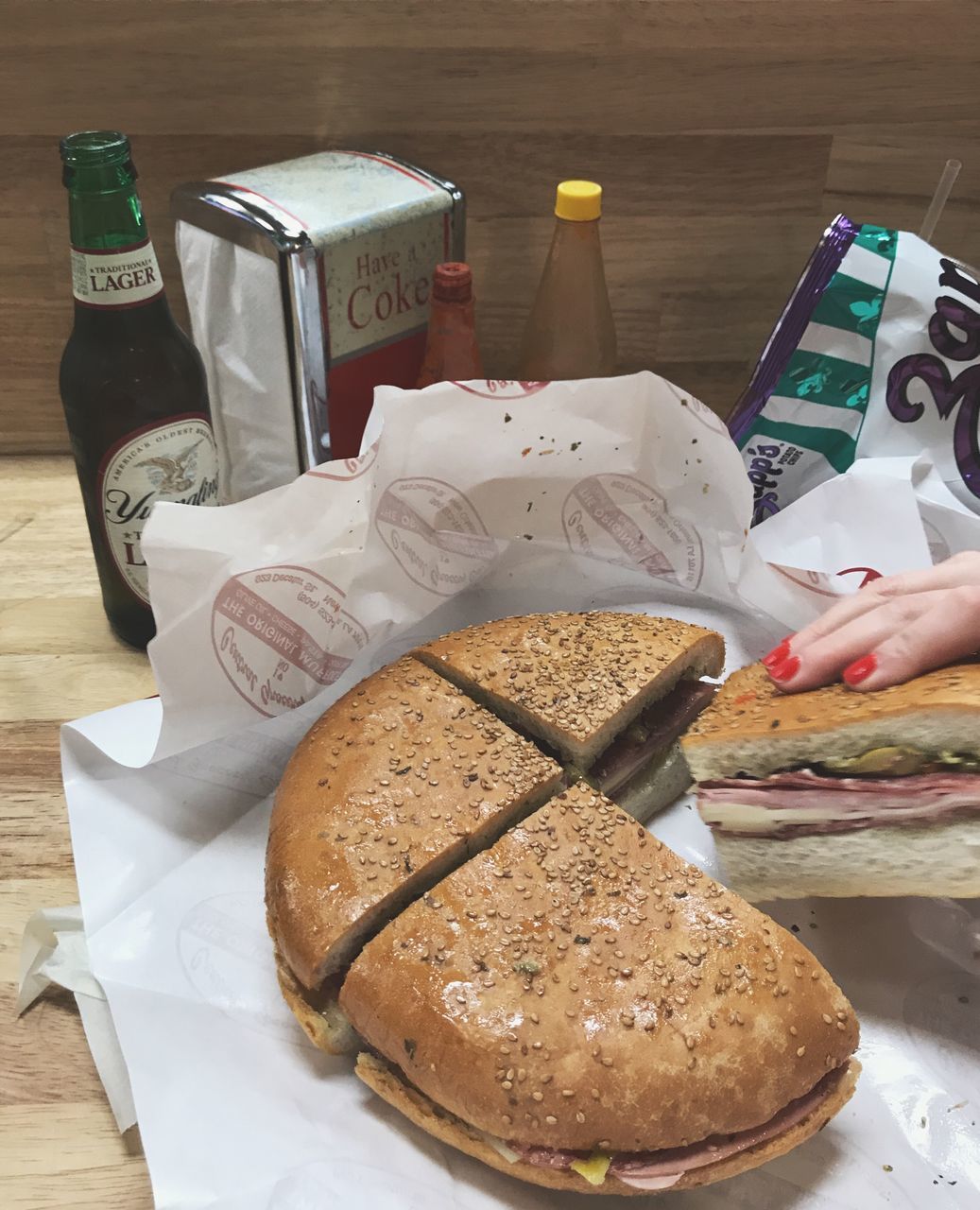 food and drink, food, human hand, hand, indoors, human body part, freshness, table, one person, close-up, holding, real people, bread, container, sweet food, baked, indulgence, bottle, high angle view, temptation