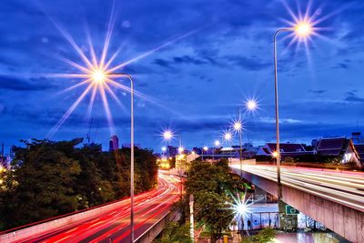 Light trails on street against sky at night